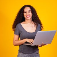 remote-work-portrait-of-excited-young-afro-woman-holding-laptop-computer-isolated-over-yellow-background-copyspace-for-text
